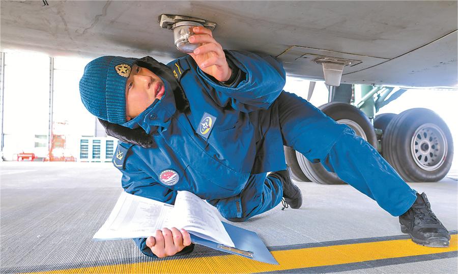 機(jī)務(wù)兵冒著嚴(yán)寒檢查戰(zhàn)機(jī)。.jpg